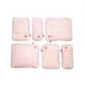 Set of pink travel packing cubes with visible brand logo on a white background