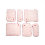 Set of pink travel packing cubes with visible brand logo on a white background