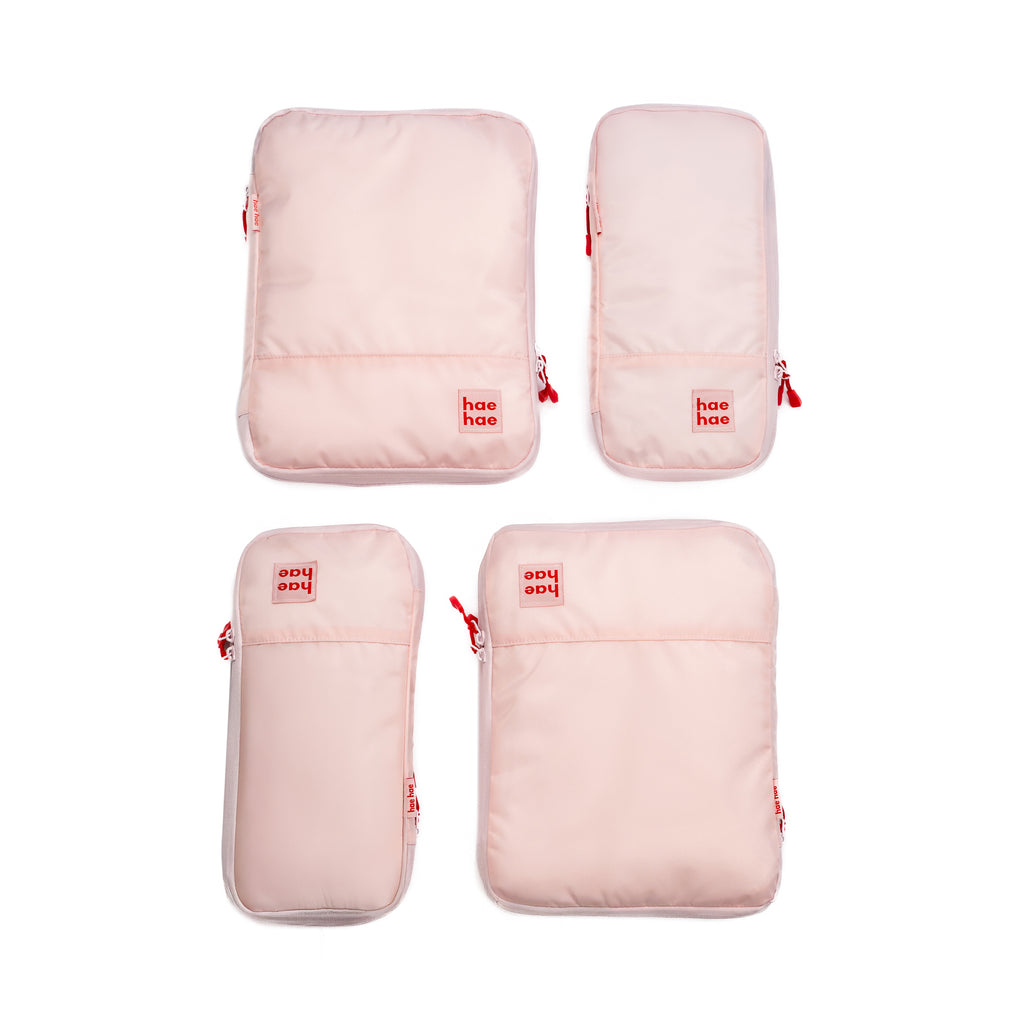 Set of four pink travel bags with 'hae hae' branding on a white background