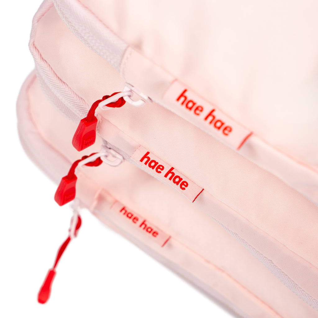 Pink blossom hae hae packing cubes close up of the red detail zips