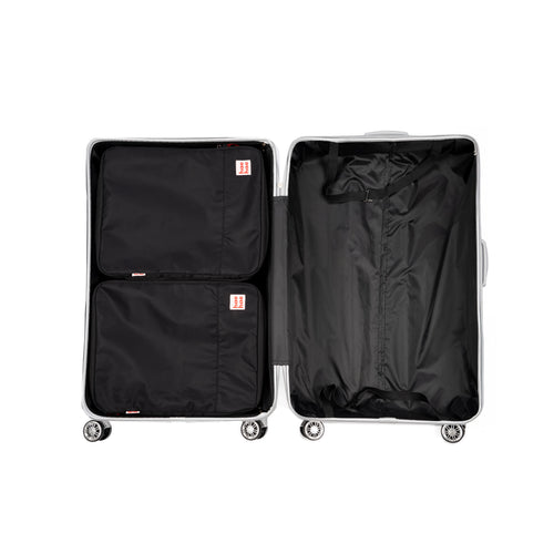 Two large compression packing cubes in silver open suitcase on a white background