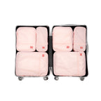 6 Pink packing cubes in an open suitcase on a white background, hae hae