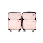 4 pack pink travel compression packing cubes within a suitcase on a white background
