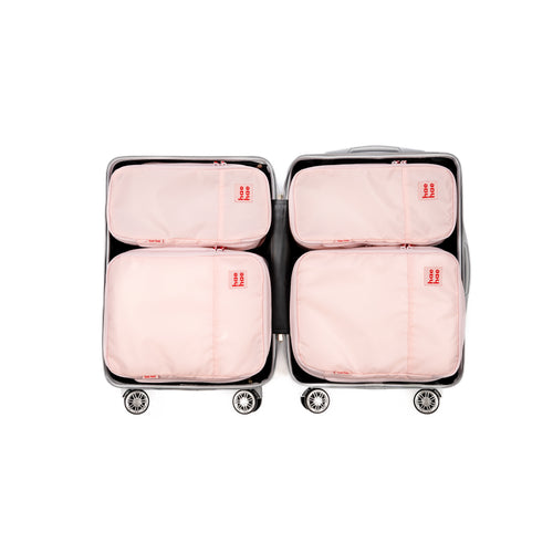4 pack pink travel compression packing cubes within a suitcase on a white background
